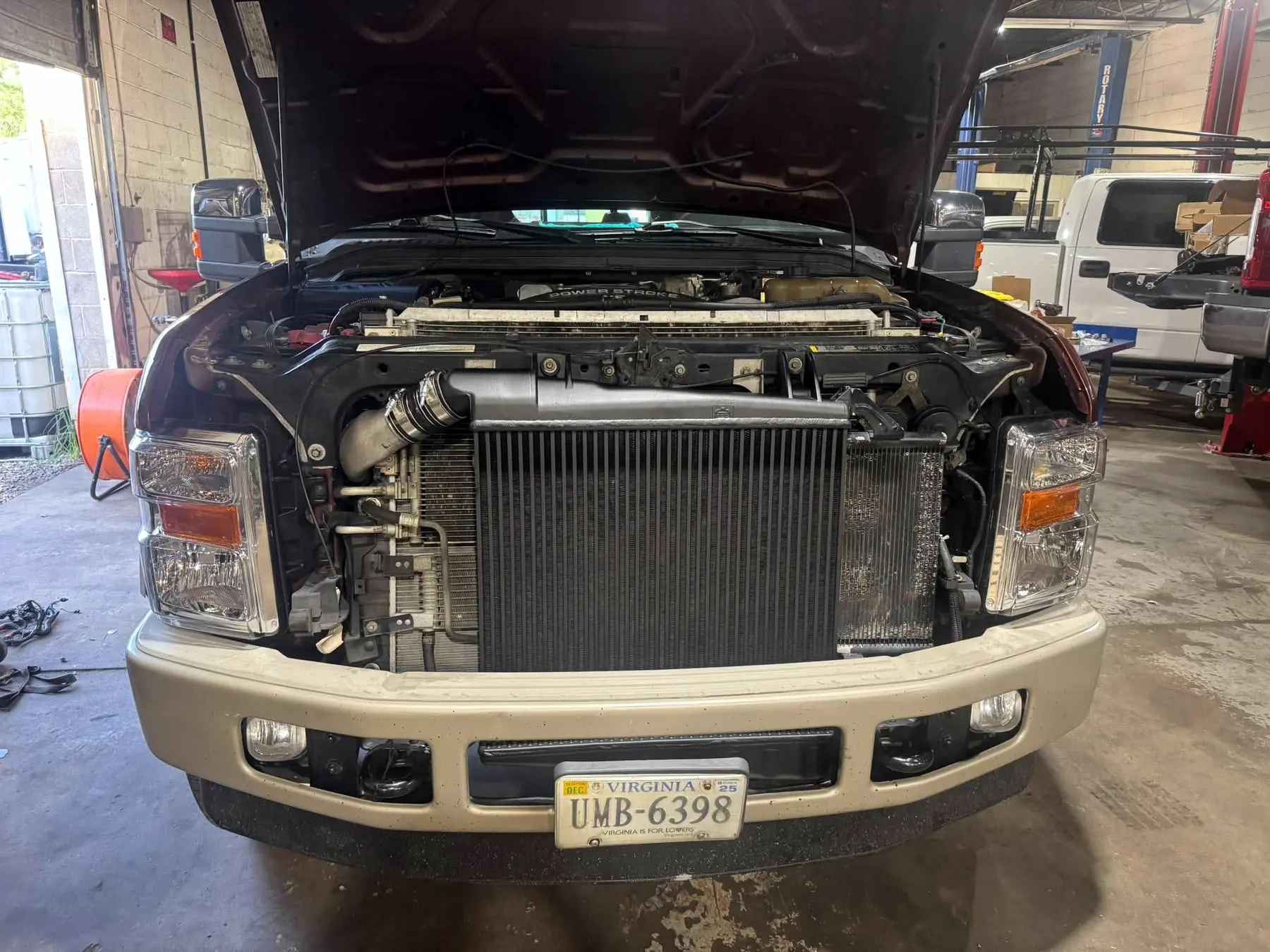 Radiator, intercooler and condenser stack exposed at the front of a Ford Super Duty during a radiator replacement