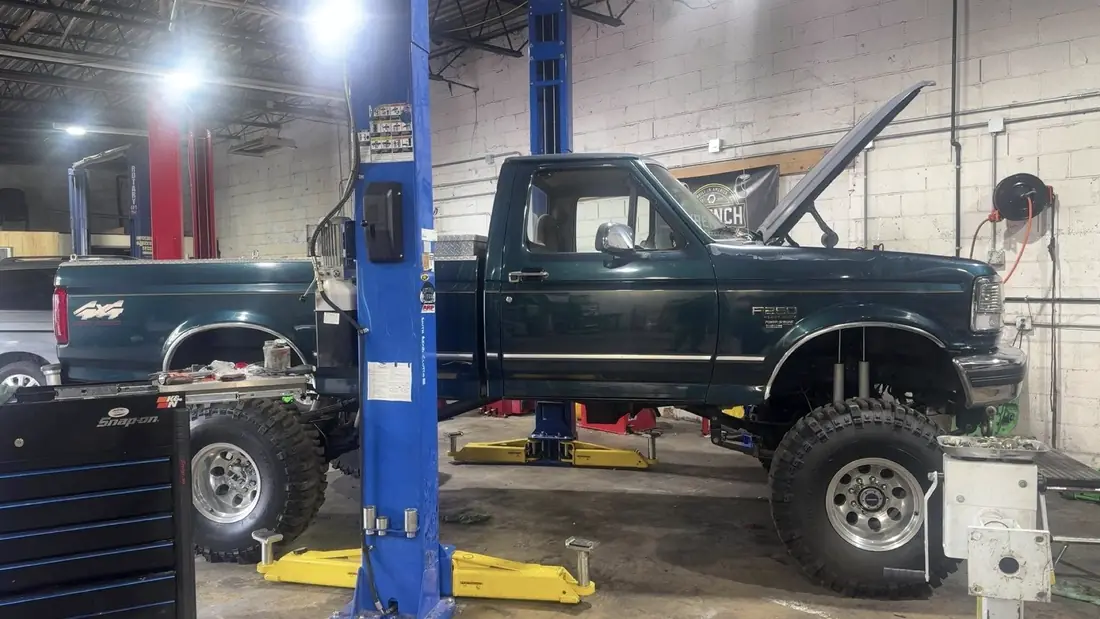 Older Ford F-250 raised on the lift for a rebuild