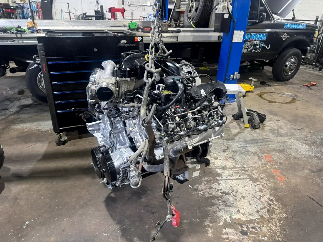 Duramax diesel engine lifted out of a truck on an engine crane
