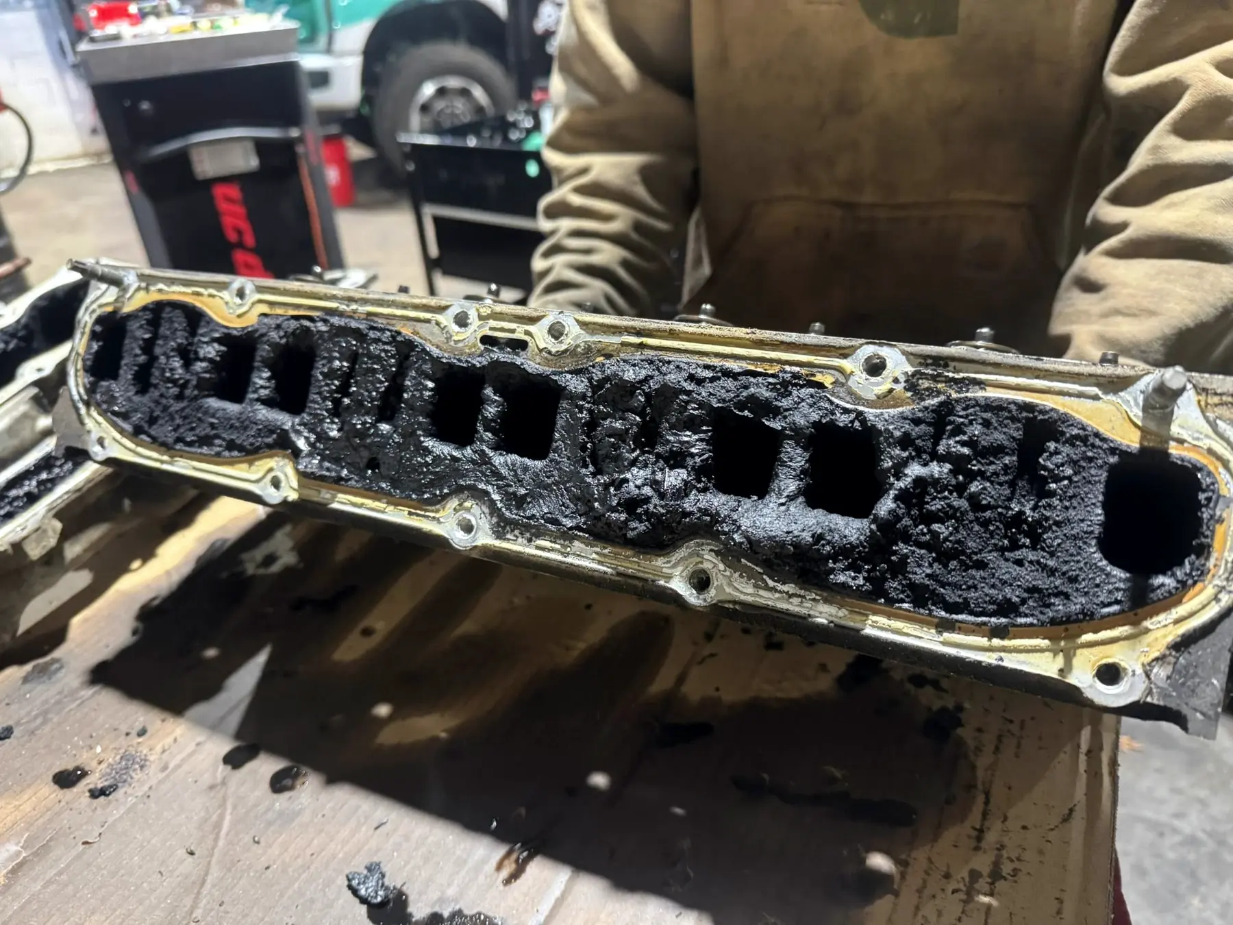 Intake manifold caked with carbon and soot, removed from a diesel engine