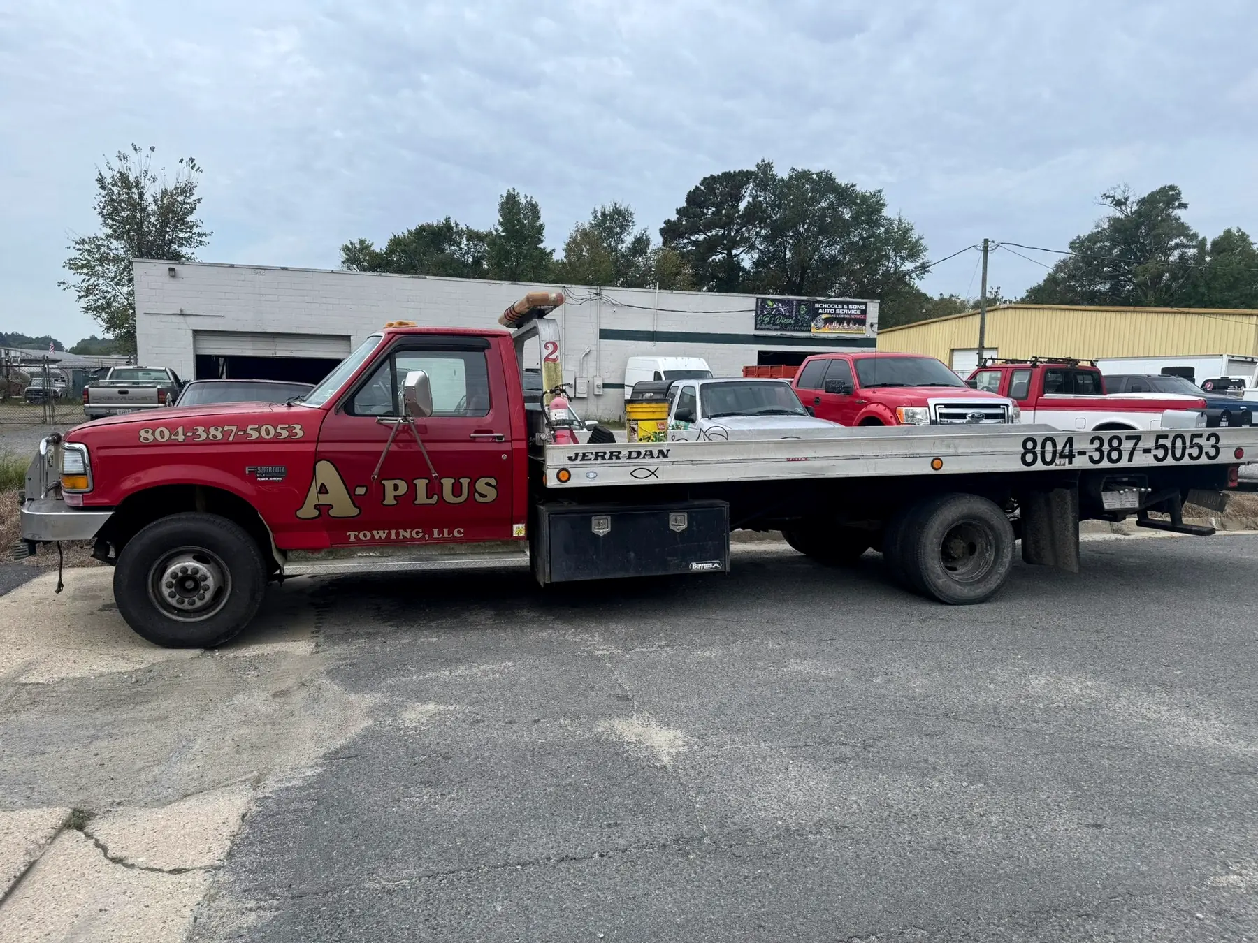 A-Plus Towing flatbed wrecker parked outside CBS Diesel