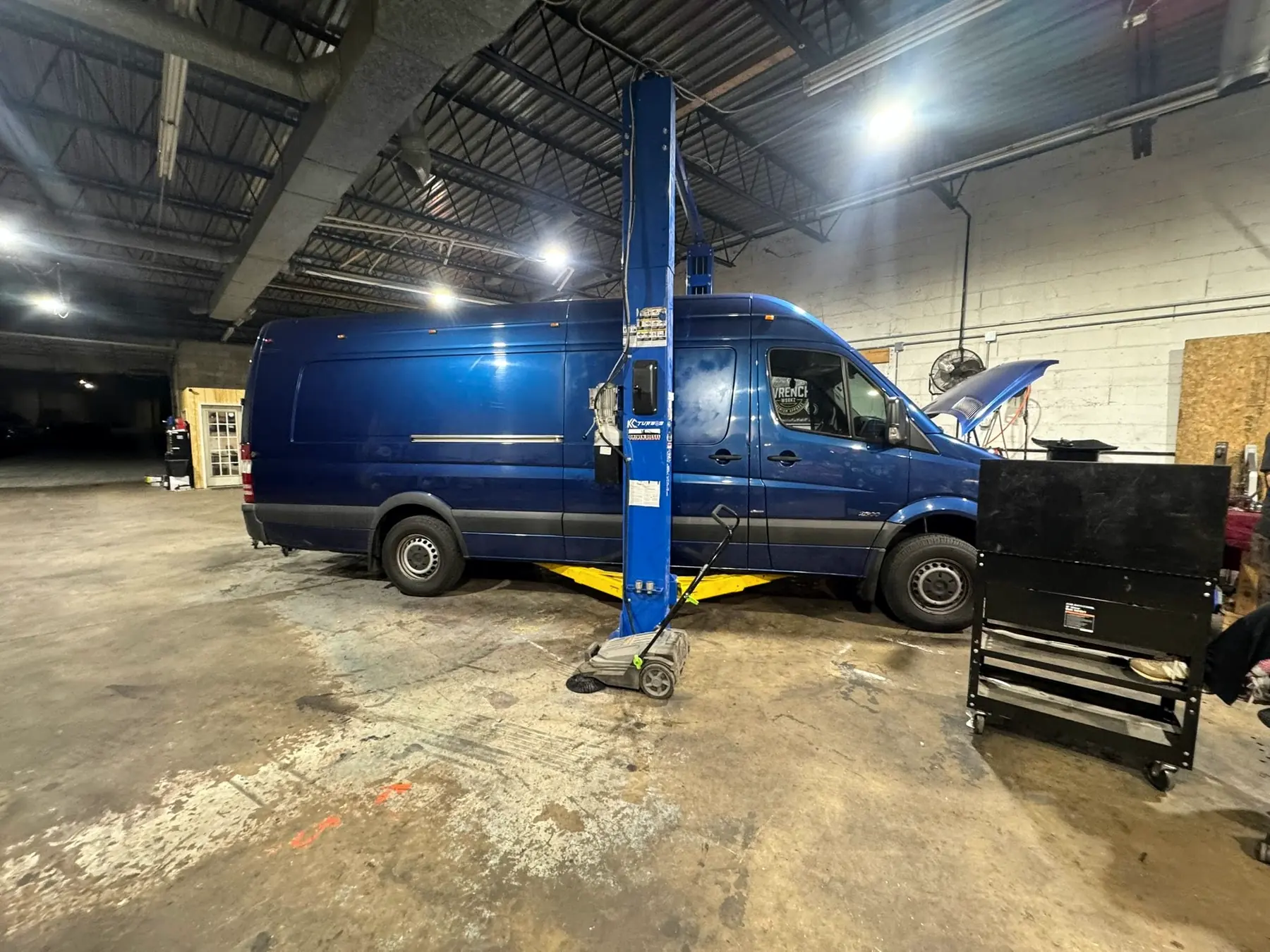 Blue Sprinter van raised on the lift at CBS Diesel