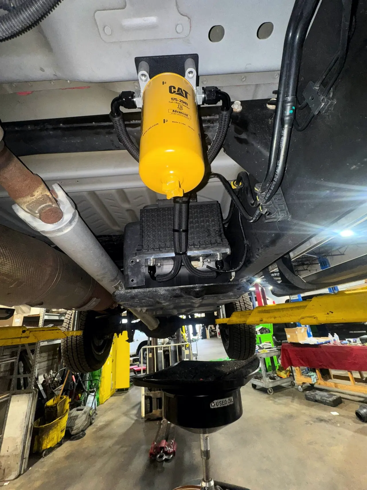 CAT fuel filter and transmission seen from under a lifted diesel truck