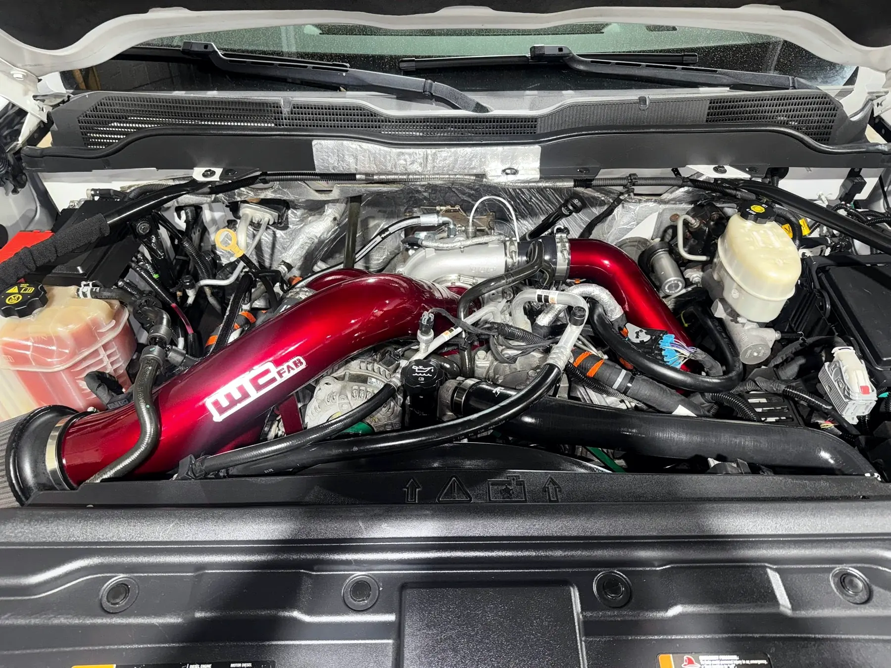 Diesel engine bay with a red aftermarket cold air intake fitted