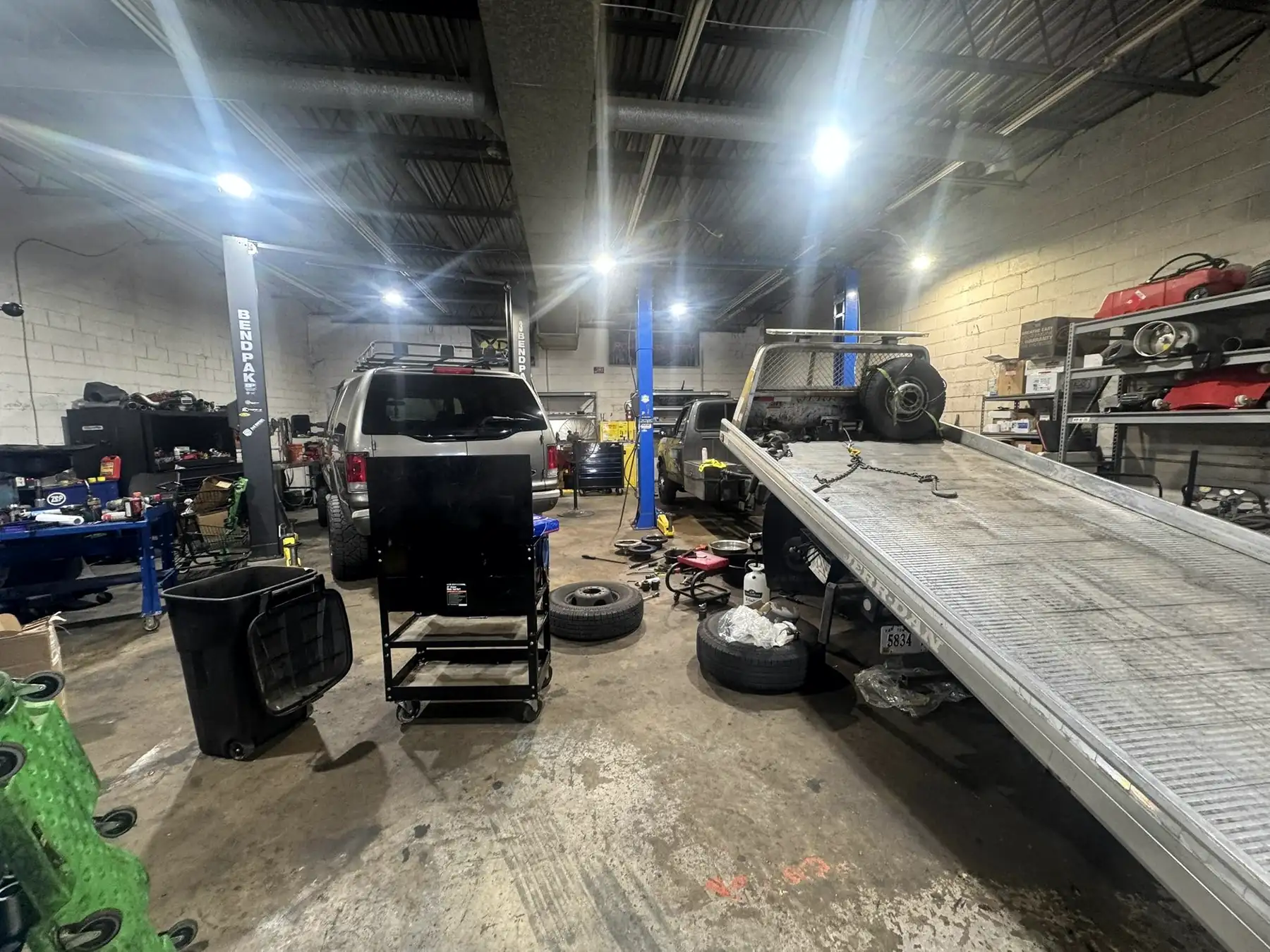 Wide view of the CBS Diesel shop with a flatbed truck and open bay door