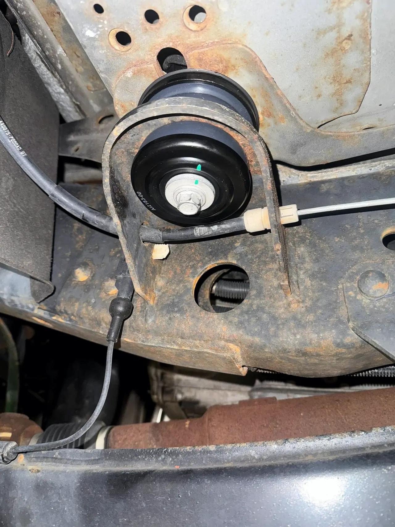 New S&B cab bushing fitted in the body mount bracket on a diesel truck frame