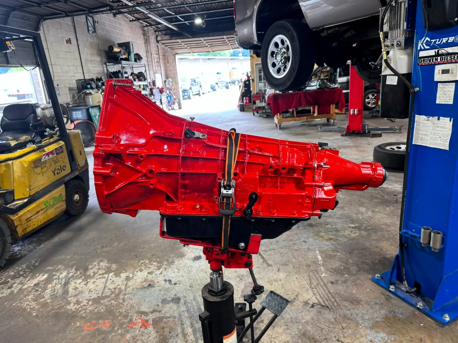 Rebuilt transmission on a transmission jack, painted red, ready to go back in