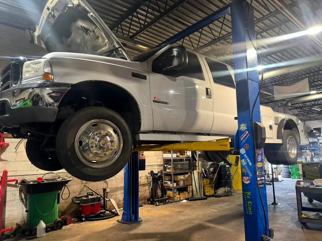 White Ford F-450 Centurion raised on the two-post lift