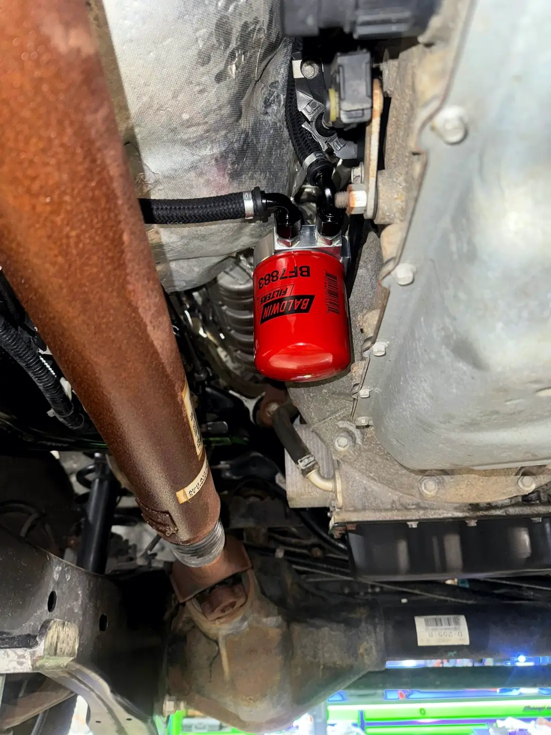 Exhaust and oil filter seen from under a raised truck