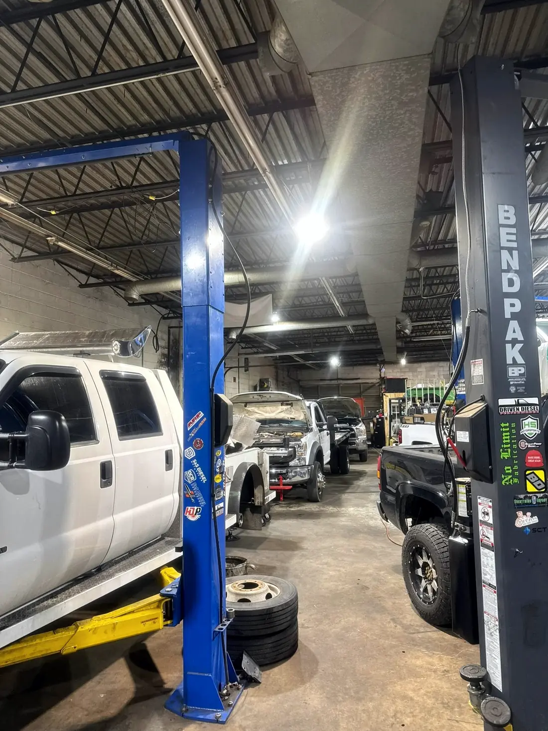 White Ford Super Duty raised on the lift