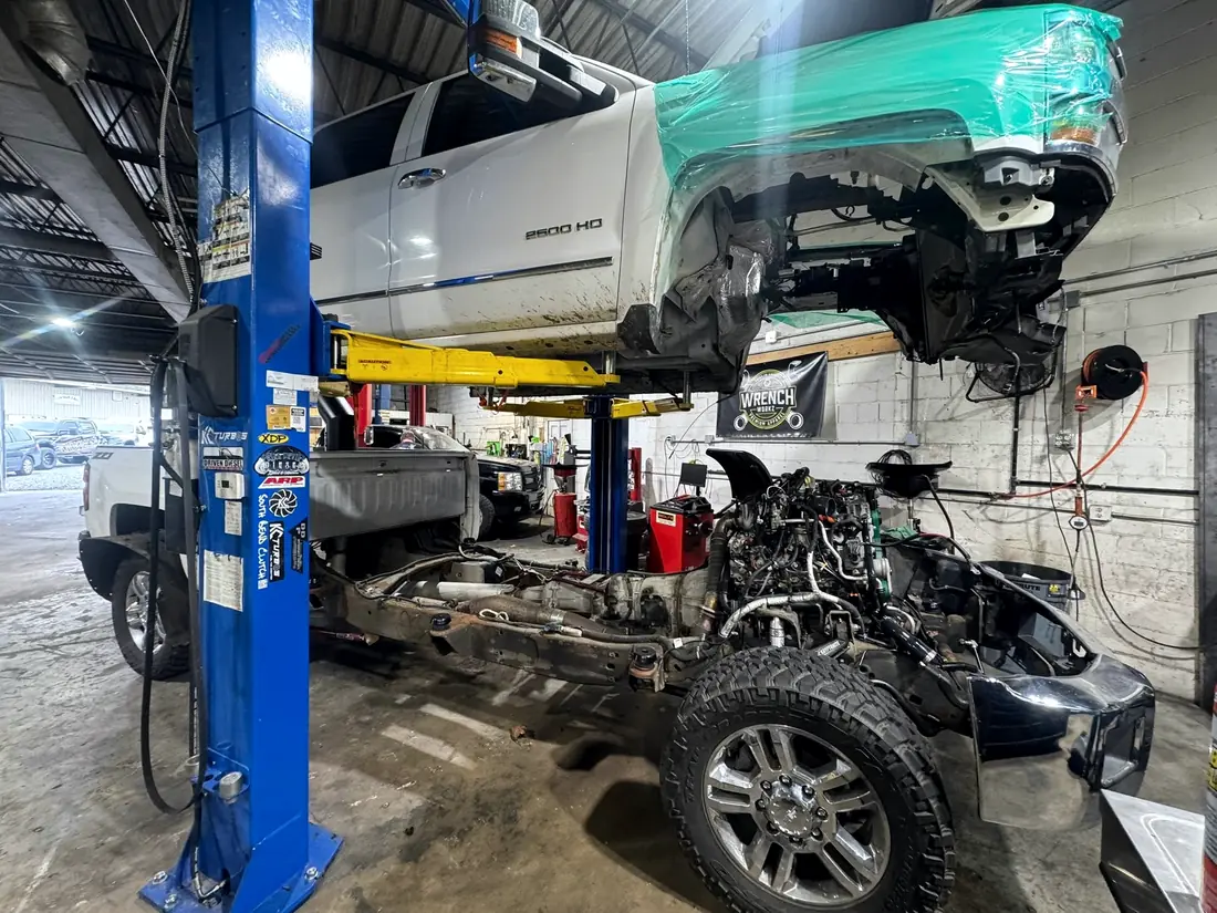 White Chevrolet 2500HD with the cab off on the lift