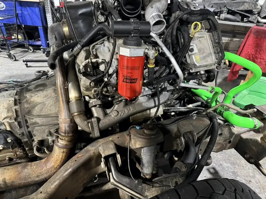 Underside of a diesel engine with a new oil filter and green hoses