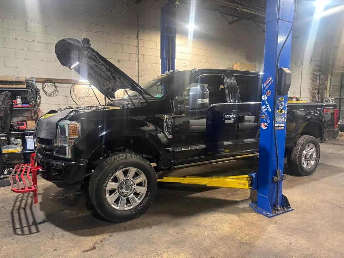 Black Ford F-250 raised on the lift