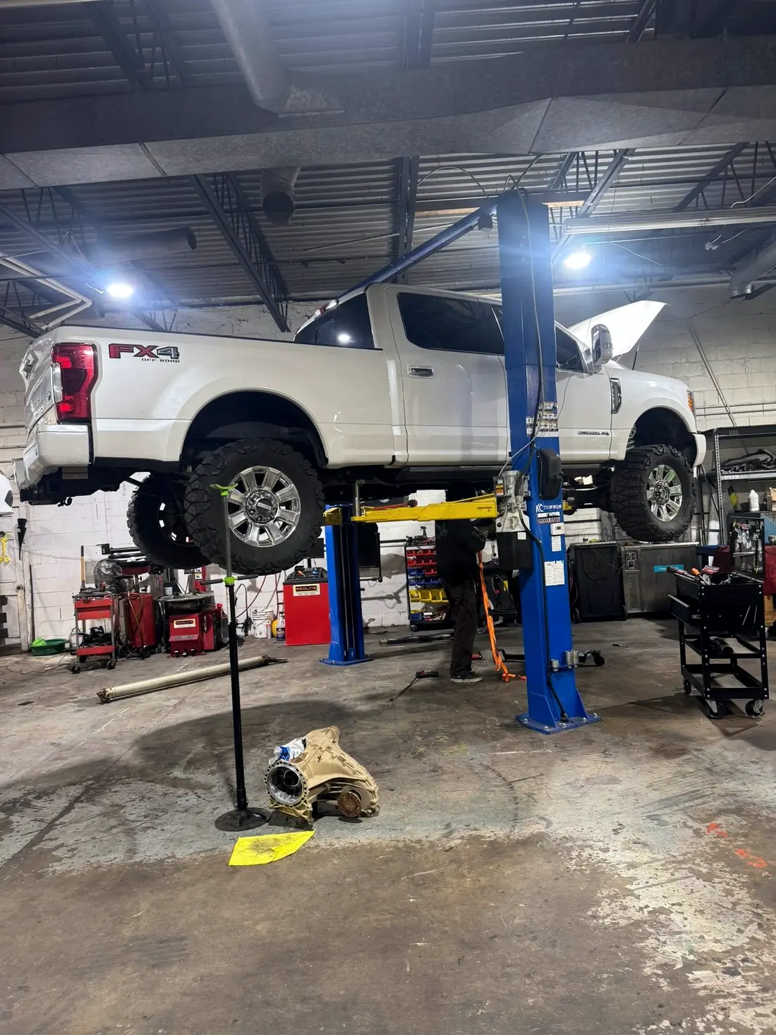 White Ford FX4 raised on the two-post lift