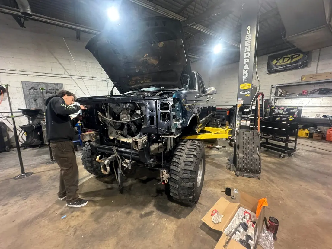 Technician working on the front end of an OBS Ford