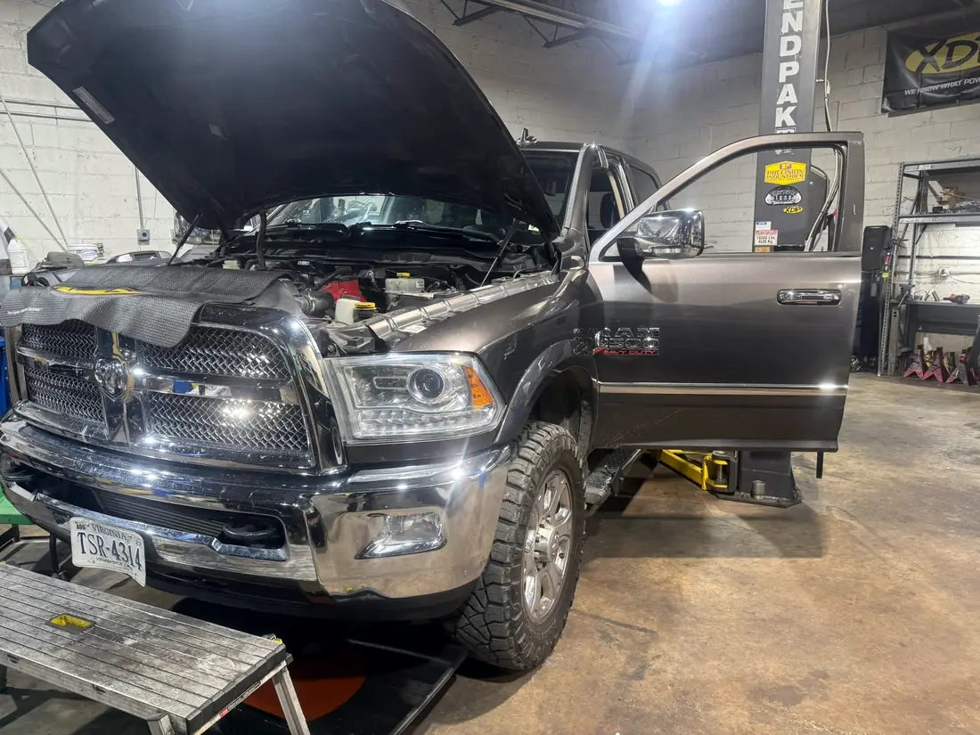 Gray Ram 2500 Laramie in the shop with the hood up