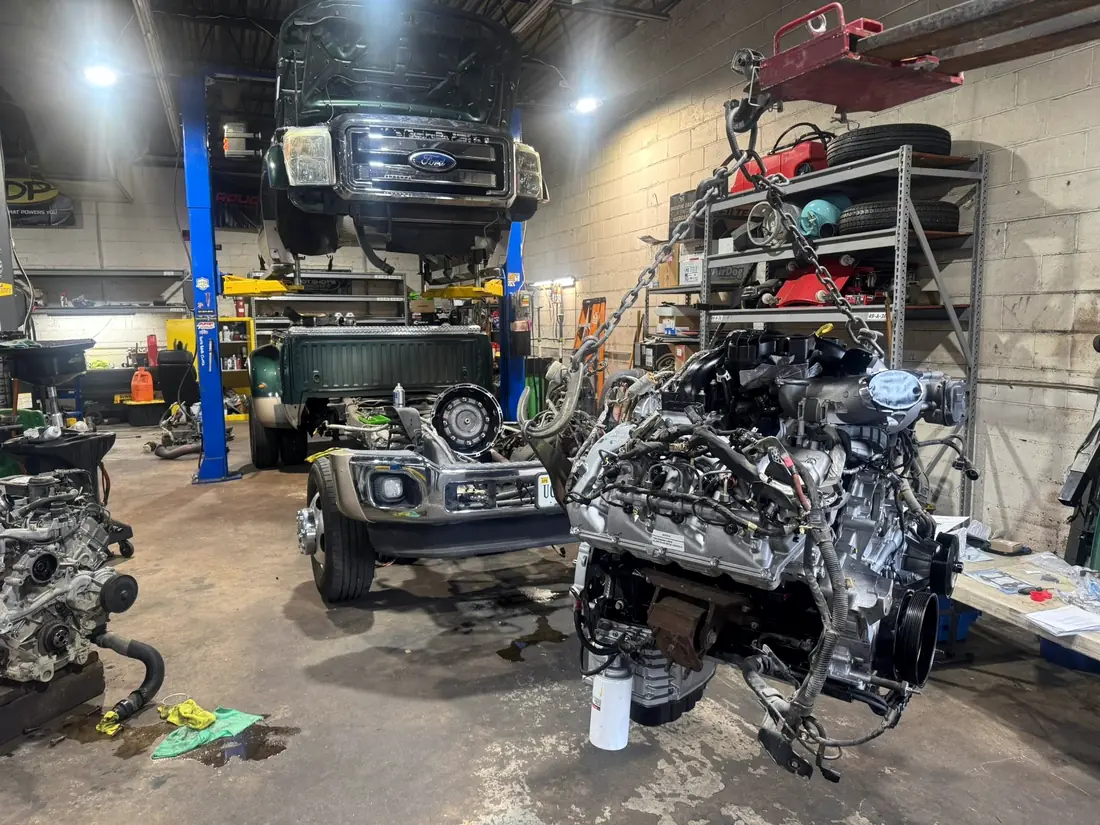 Cab-off truck and a stripped engine in the workshop