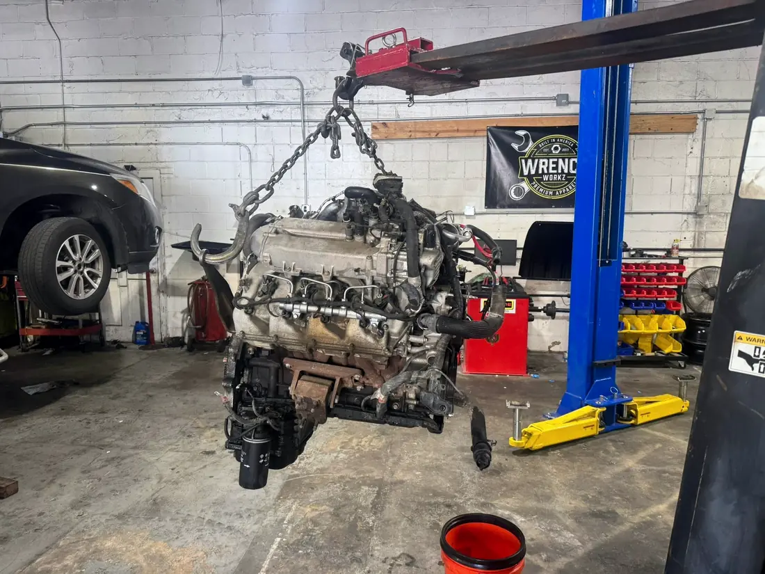 Diesel engine lifted on a crane in the shop