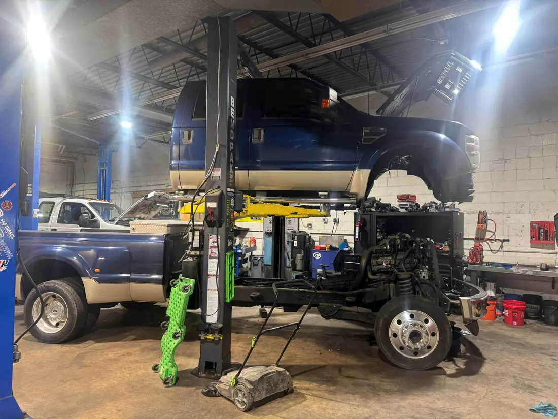 Blue Ford F-450 dually raised on the lift