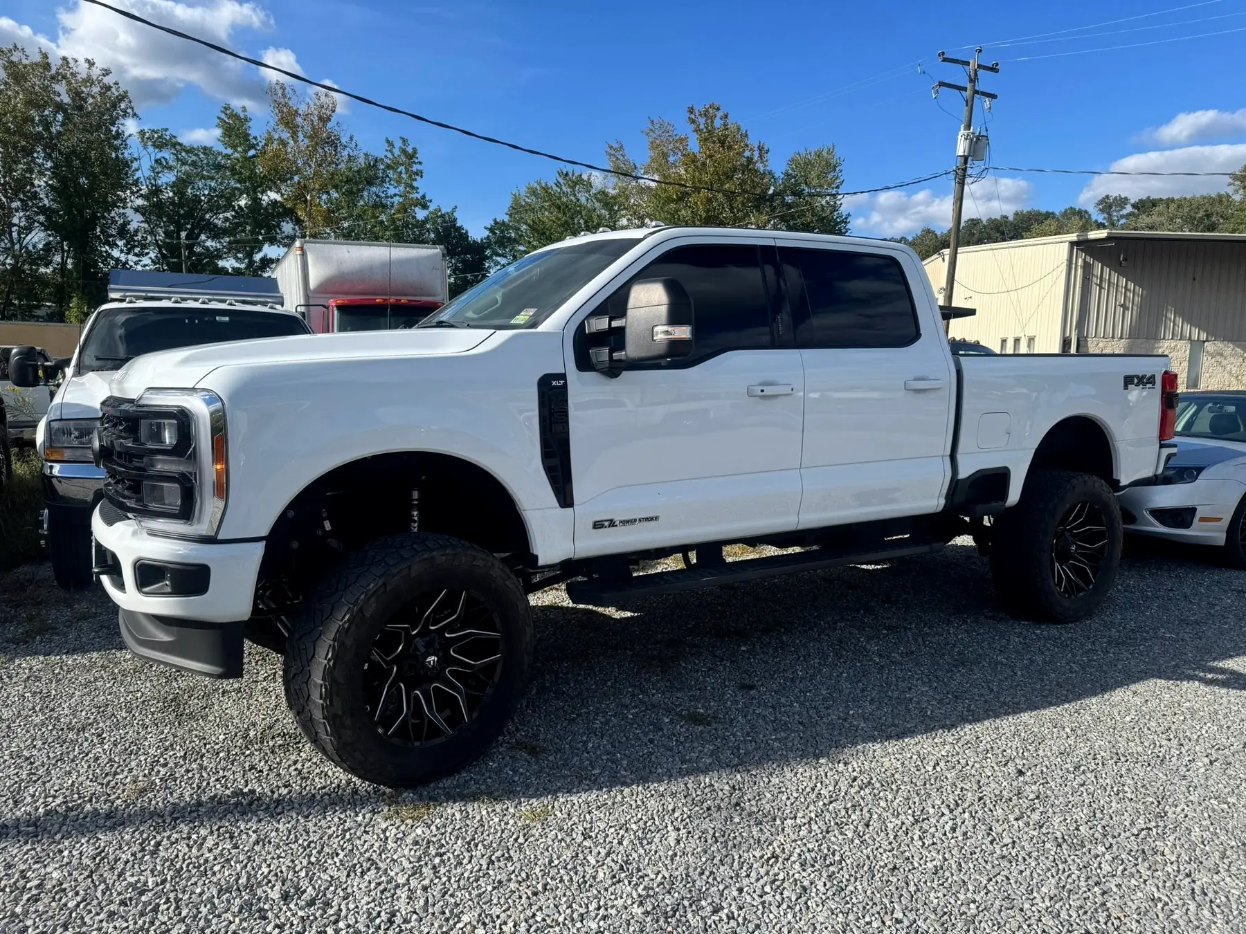 White Ford F-250 on aftermarket wheels and tires, lifted